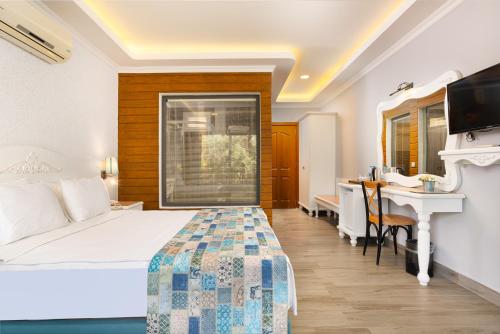 a hotel room with a bed and a desk at Hotel Karbel Sun in Oludeniz