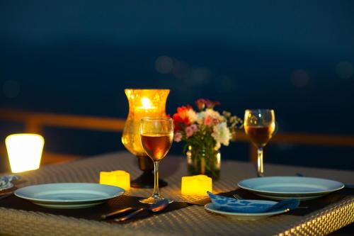 a table with two glasses of wine and plates and flowers at The Xanadu, Coonoor in Coonoor