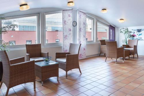 a waiting room with chairs and tables and windows at First Hotel Statt Örnsköldsvik in Örnsköldsvik