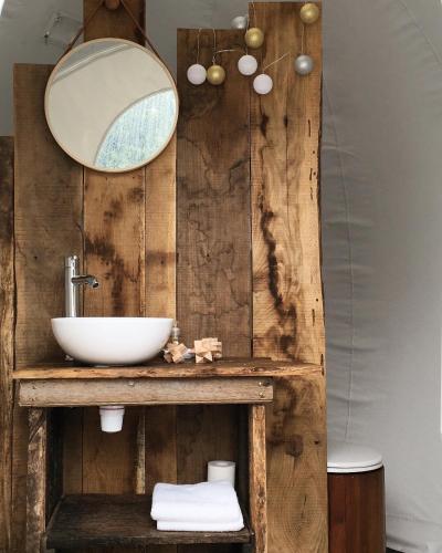 une salle de bain avec un lavabo et un miroir dans l'établissement domaine des butineuses, à Marchainville