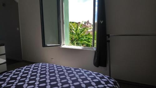 a bedroom with a bed and a window at Le patio d'olivier in Lalinde