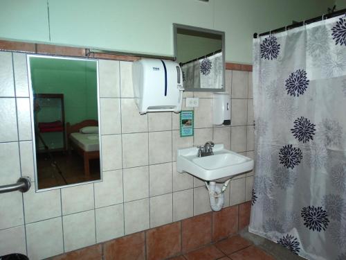 a bathroom with a sink and a shower curtain at La Selva Biological Station in Sarapiquí