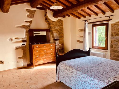 a bedroom with a bed and a tv and a window at La Casa di Elia in Arcidosso