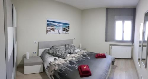 Un dormitorio con una cama con almohadas rojas. en Apartamento Barajas. Aeropuerto/Ifema en Madrid