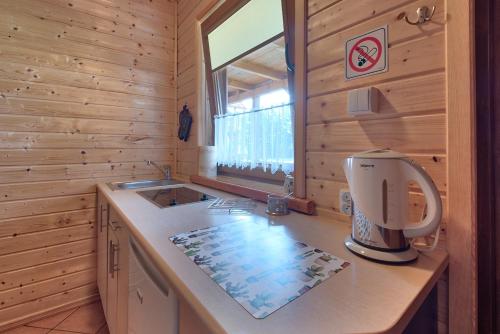 a kitchen with a counter with a coffee maker on it at DARMAT Domki Letniskowe in Stegna