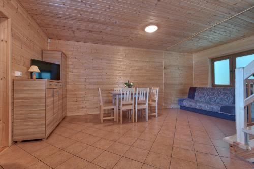 a living room with a table and a couch at DARMAT Domki Letniskowe in Stegna