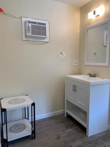 a bathroom with a sink and a mirror at Green Acre Motel in Lake George