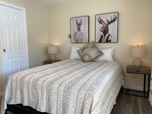 a bedroom with a bed with two pictures of deer on the wall at Green Acre Motel in Lake George