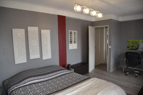 a bedroom with a bed and a red wall at au calme in Anglet