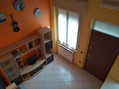 um quarto laranja com uma porta e uma janela em Casa vacanze IL VIOLINO em Cremona