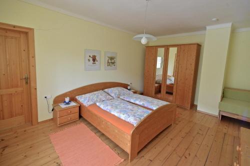 um quarto com uma cama e piso em madeira em Müllnerbauer em Penk