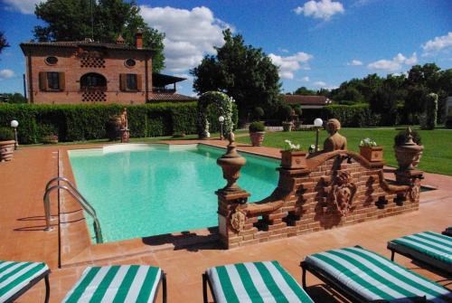 una piscina en un patio con una casa en Villa Portoverde, en Foiano della Chiana