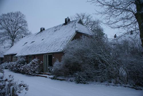 a house with snow on the roof of it at Under the Oaks in Diever