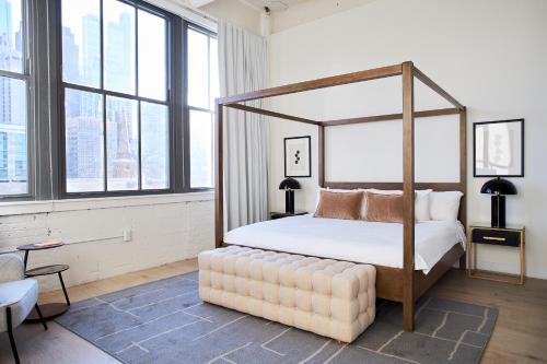 1 dormitorio con cama con dosel y ventana grande en Sonder at Sixteen Hundred en Filadelfia