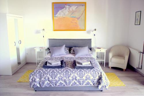 a bedroom with a bed and two tables and a chair at Studio apartment Gray in Šibenik