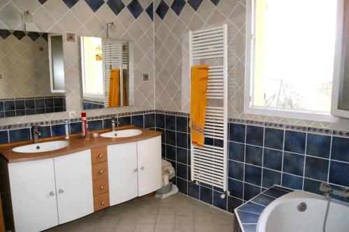 Mirabel-aux-Baronnies的住宿－L' oliveraie，浴室配有2个盥洗盆和1个浴缸。