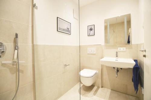 a bathroom with a toilet and a sink and a shower at Modern apartment near downtown in Munich