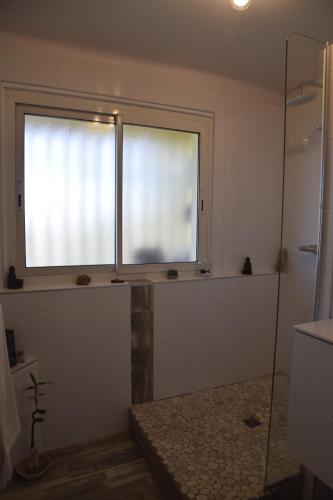a bathroom with a shower and a window and a tub at au calme in Anglet