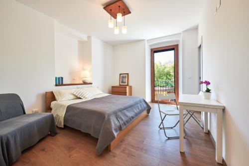 a bedroom with a bed and a desk and a window at Stazione 8 in Aurisina