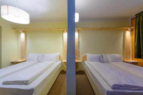 two beds in a room with two beds sidx sidx sidx at Park Hotel Faloria in Canazei