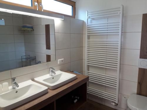 a bathroom with two sinks and a mirror and a shower at Ferienhaus Bernadette in Mauterndorf