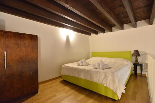 a bedroom with a bed with a green headboard at IzzHome City Center Cozy in Cagliari