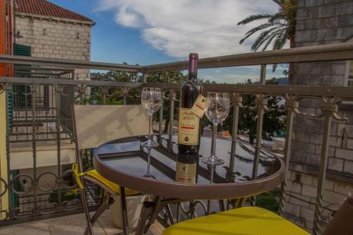 einen Tisch mit zwei Gläsern Wein auf dem Balkon in der Unterkunft Apartmani Skver Sanja in Herceg-Novi