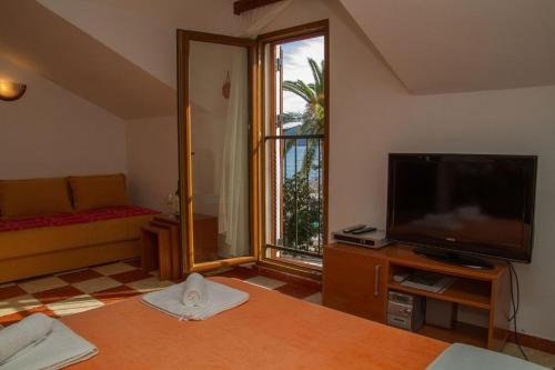 a living room with a television and a couch at Apartmani Skver Sanja in Herceg-Novi