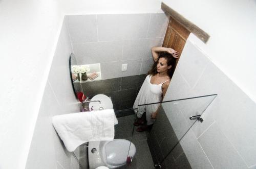 a woman is looking into a mirror in a bathroom at Moonshine Boutique Hostal in Cali