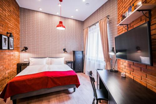 a bedroom with a bed and a desk and a tv at Revelton Studios Karlovy Vary in Karlovy Vary