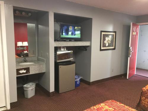 a hotel room with a television and a bathroom at Journeys End Motel in Absecon