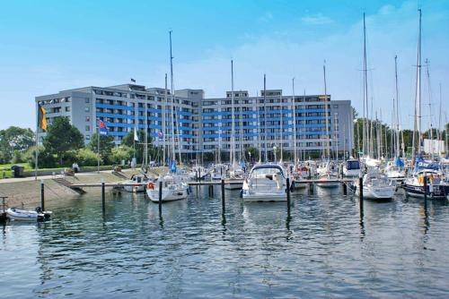 a group of boats docked in a marina with a building at Ferienwohnung zur Seeseite _ 200 m in Damp