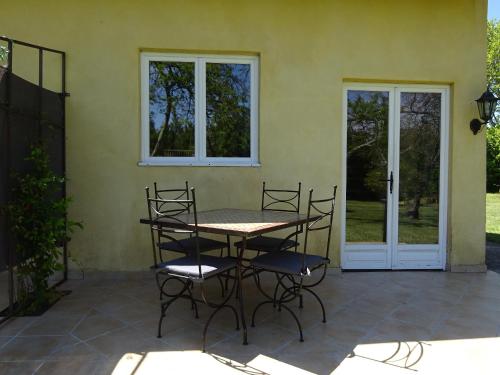 un patio avec une table et des chaises devant une maison dans l'établissement Mas de l'AGUARELLA, à Saint-Rémy-de-Provence