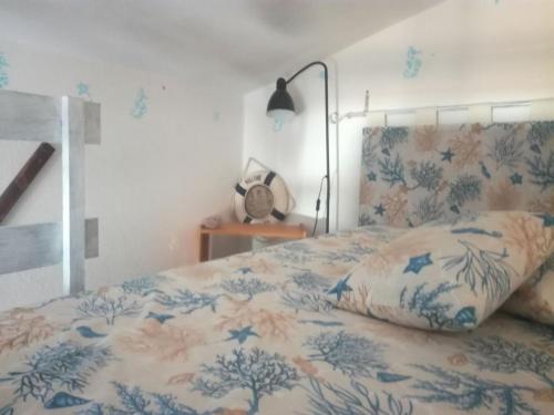 una camera con un letto con una coperta blu e bianca di Villino Nuoro a San Teodoro