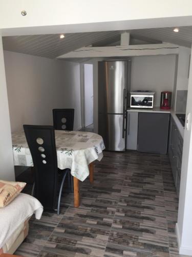 une cuisine avec une table et un réfrigérateur dans l'établissement Pousse le portail et pose toi sur la plage, à Noirmoutier-en-l'lle