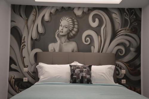 a bedroom with a headboard with a statue of a woman at S. Luxury Princess Suite in Nea Kallikrateia