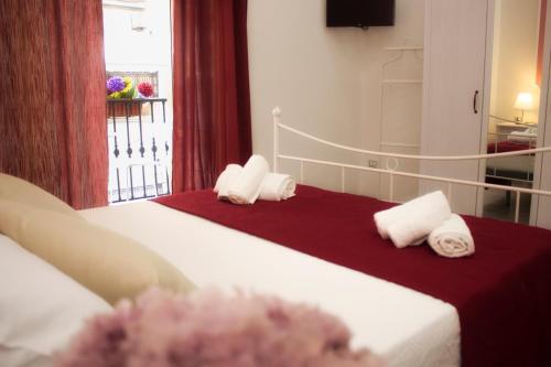 a bedroom with two beds with towels and a window at I Benvenuti al Sud in Naples