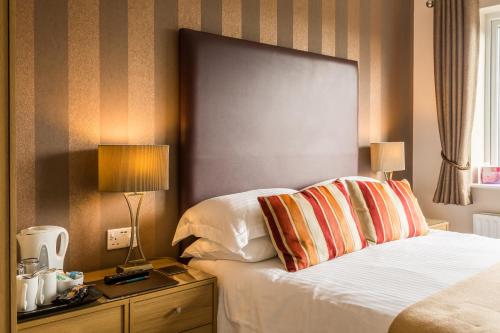a hotel room with a bed and a table with a lamp at Hermiston Guest House in Keswick