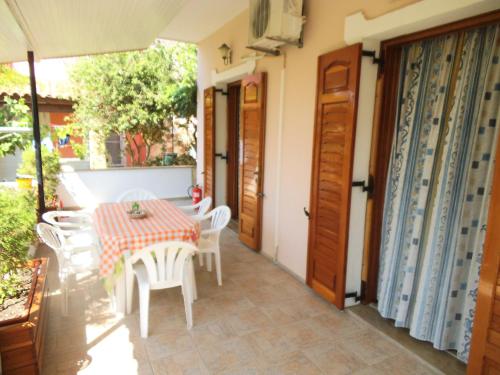 a patio with a table and chairs and an umbrella at Villa Xenos in Kalamaki