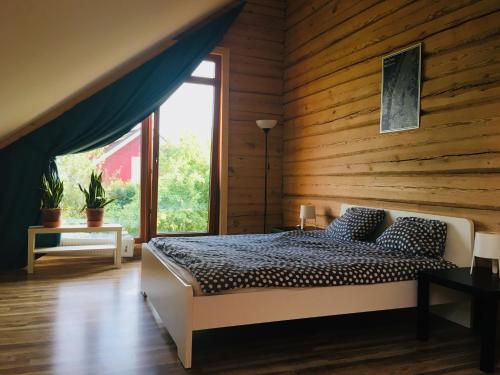 a bedroom with a bed and a wooden wall at Room in a Scandinavian Style House in Vilnius