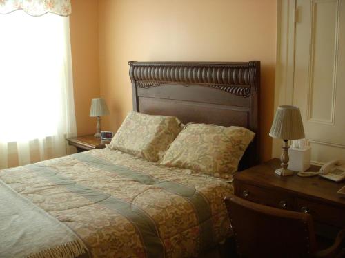 een slaapkamer met een bed en een bureau met een telefoon bij Wayne on Main in Honesdale