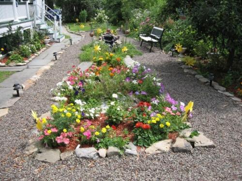 a garden with flowers and a bench in the background at Wayne on Main in Honesdale