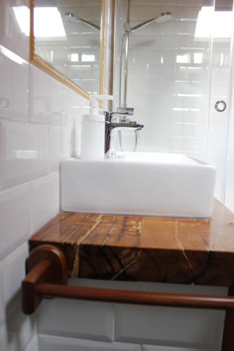 a bathroom with a white sink and a wooden table at Los Acebos in Horcajuelo de la Sierra