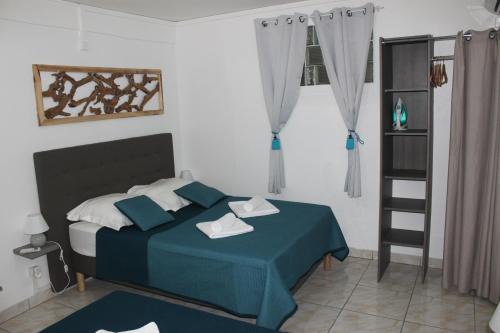 a bedroom with a bed with a blue comforter at Résidence B&L Lagon : T3 Alizés in Sainte-Luce
