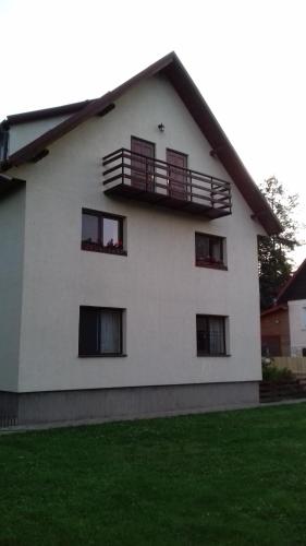 a white house with windows and a balcony at Pensiunea Simona in Bran