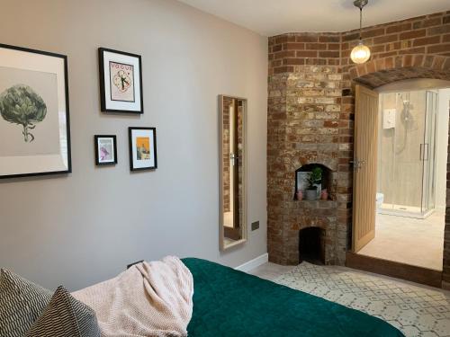 a bedroom with a brick wall and a fireplace at The Folly in Ludlow