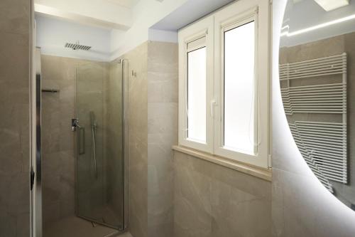 a bathroom with a shower and a window at Affittacamere Somnium in Sirolo