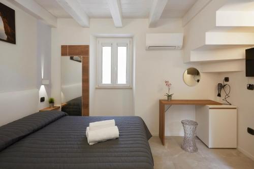 a bedroom with a bed and a desk and a window at Affittacamere Somnium in Sirolo