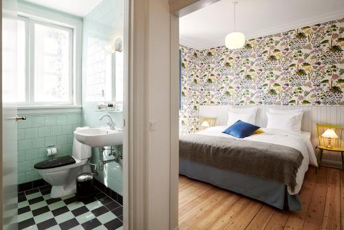1 dormitorio con 1 cama y baño con lavamanos en Villa Strand, en Hornbæk