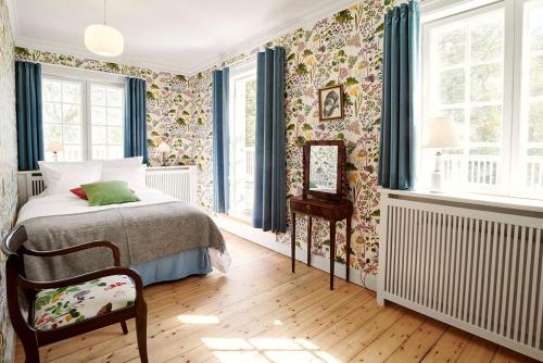 1 dormitorio con cama y papel pintado con motivos florales en Villa Strand en Hornbæk